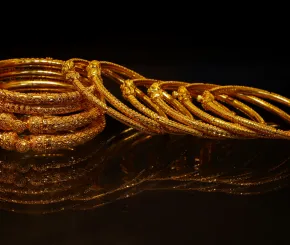 Image of gold bangles on dark background