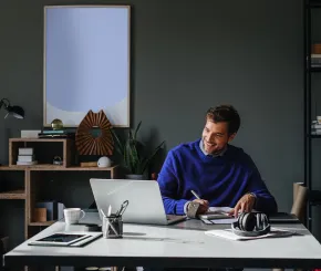 Business man working on his laptop at his modern office desk