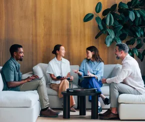 Team discussing while sat on sofa and chair