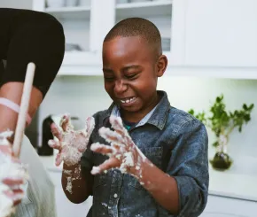 Happy boy baking with dough