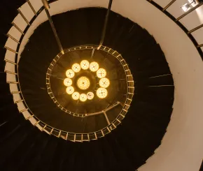 ancient_spiral_staircase_in_a_tall_tower_with_lamp_light_1.jpg