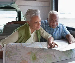 a couple planning their retirement adventure looking at a map