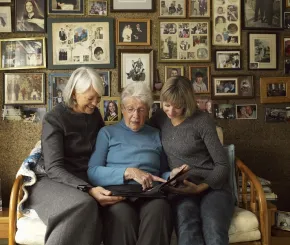 3 generations of women looking at photo albums