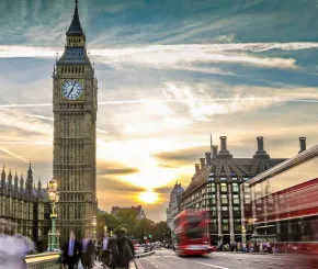 city of London facing Big Ben with an onrushing London red bus
