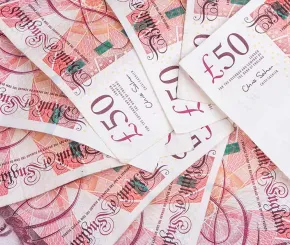 Fifty-pound sterling notes in a pile