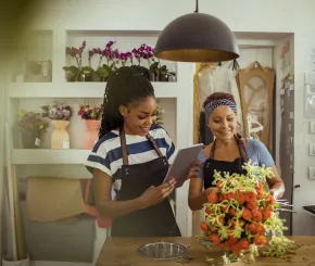 Two smiling women in a flower shop