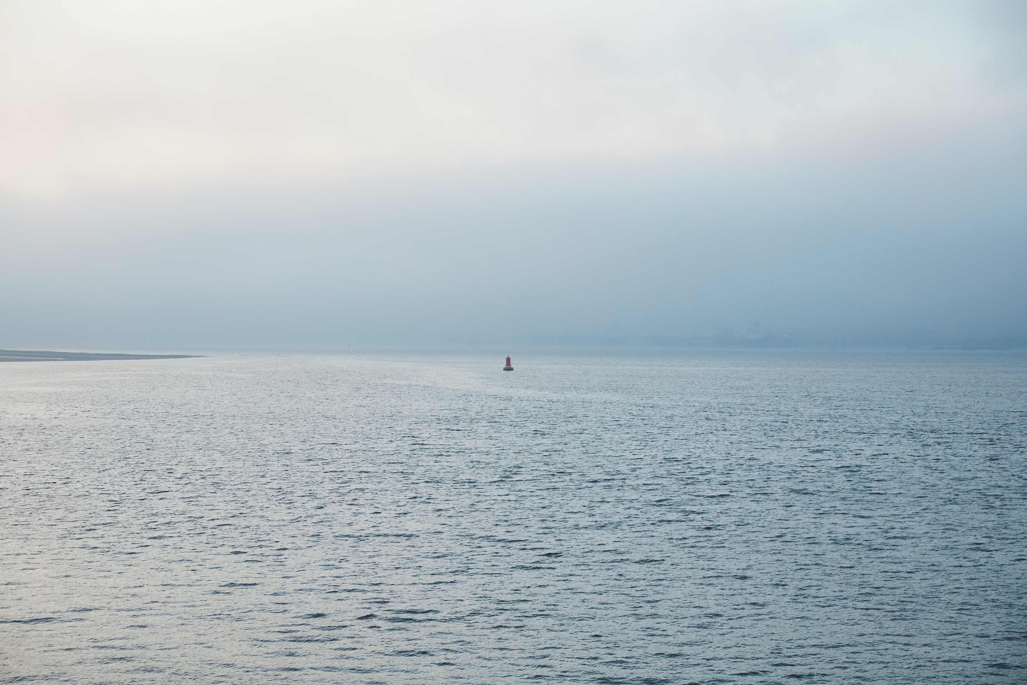 Looking across a big sea with a tiny bouy in the distance