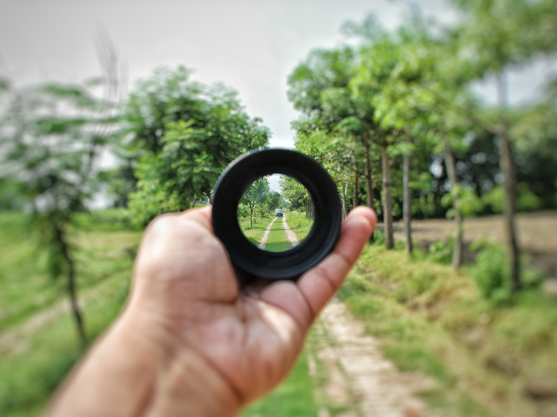 focus on distance in a farmer's field looking through a lens investment insights