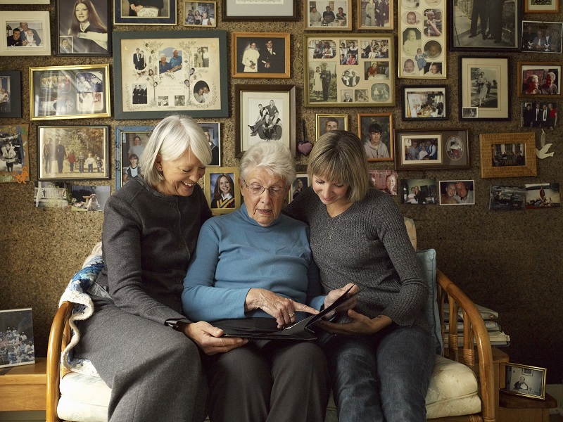 3 generations of women looking at photo albums