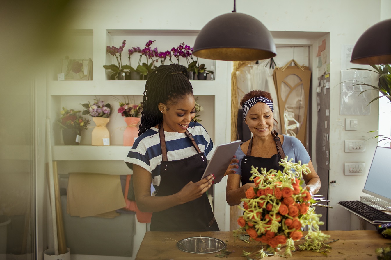 Two smiling women in a flower shop