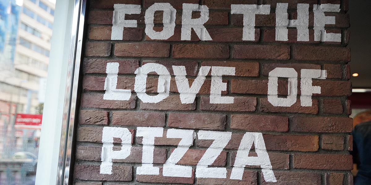 For the love of pizza writing on a restaurant wall
