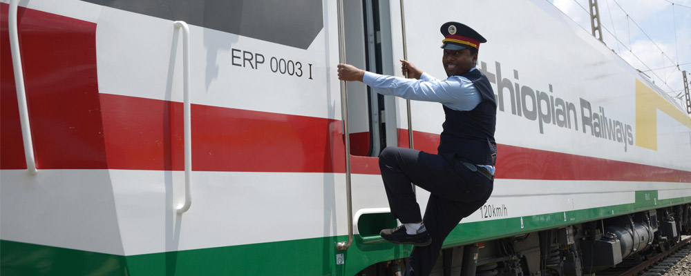 Conductor climbing onto Ethiopian Railways train - Rathbone Investment Management Conductor climbing onto Ethiopian Railways train - Rathbone Investment Management
