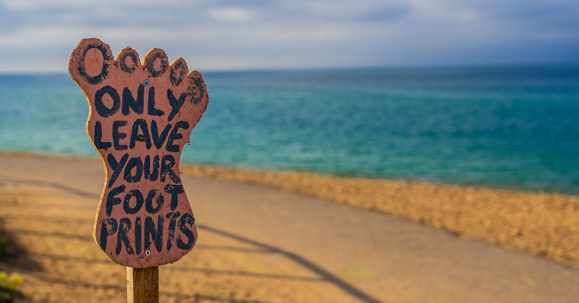 A long voyage in search of greener lands Foot print sign on the beach