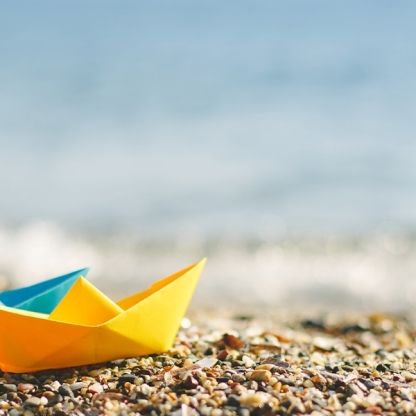 Folded paper boats on beach