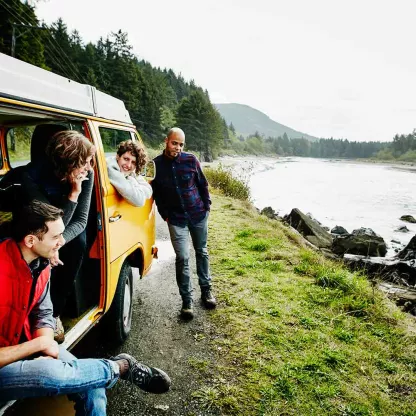 Young family with teenagers on a campervan holiday by the river