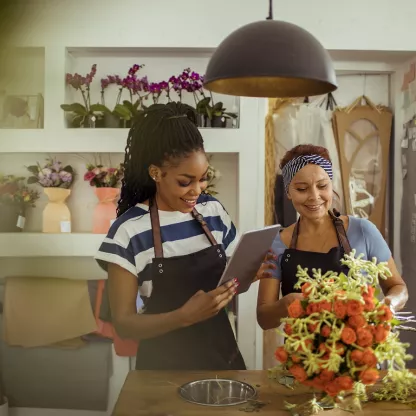 Two smiling women in a flower shop